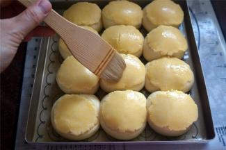 在发酵好的面包上刷上少量清水，将擀好的酥皮盖在上面，用刀在酥皮划上花纹，并刷上少量的蛋黄液。