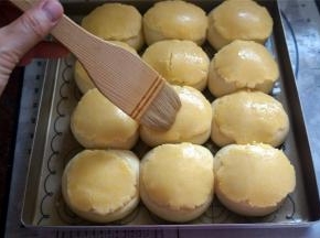 在发酵好的面包上刷上少量清水，将擀好的酥皮盖在上面，用刀在酥皮划上花纹，并刷上少量的蛋黄液。