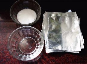 将高度白酒以及食盐分别装到大碗里，同时准备一叠锡纸（大小能包裹住整个鸡蛋就行）。