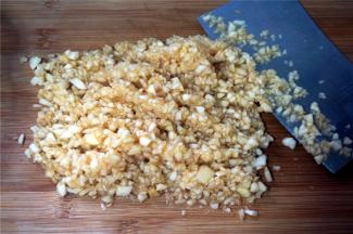 将果肉平均分成两份，一份切成0.7厘米长的小丁状，另一份切成碎末备用。