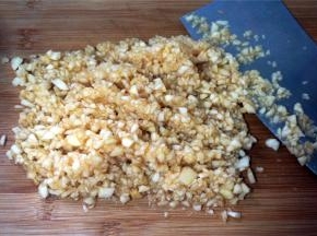 将果肉平均分成两份，一份切成0.7厘米长的小丁状，另一份切成碎末备用。