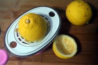 柠檬洗净后切开两半，用榨汁器榨汁，称量35克柠檬汁备用。