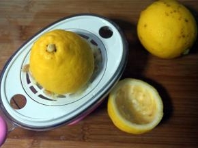 柠檬洗净后切开两半，用榨汁器榨汁，称量35克柠檬汁备用。