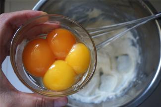 分两次加入蛋黄到面糊中，拌均匀。