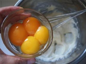 分两次加入蛋黄到面糊中，拌均匀。