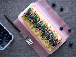 表面装饰：蛋糕卷表面先抹上一层蓝莓果酱，然后用巧克力奶油拉线装饰，最后放上蓝莓，摆上薄荷叶，完成。