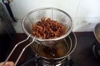 大火起油锅，油温120度以上时，放入糖核桃油炸至金黄色，出锅。