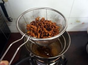 大火起油锅，油温120度以上时，放入糖核桃油炸至金黄色，出锅。