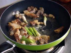 然后放入蒜头和蒜段，翻炒片刻。