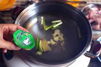 汤锅中放入蒜白，姜片，两片家乐浓汤宝，然后加入半锅清水。