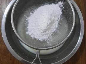 3、将糯米粉、粘米粉和澄粉过筛后倒入牛奶液中。