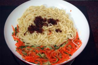 然后放入车仔面，XO酱，姜汁，鸡精，盐，快速翻炒均匀。