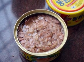 然后倒入整盒金枪鱼罐头，加入适量的酱油，快速翻炒。