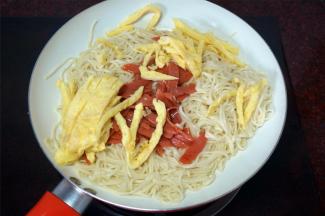 然后倒入蛋丝和火腿肠，翻炒均匀。