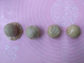 饼皮用手按扁成圆形，包入莲蓉蛋黄馅，利用虎口慢慢往上推，收口收圆