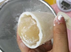 月饼压模装好花片，里面先撒一圈玉米淀粉，倒出多余淀粉，然后放入滚过淀粉的月饼坯，月饼皮尽量不要被压模外围的棱角刮破