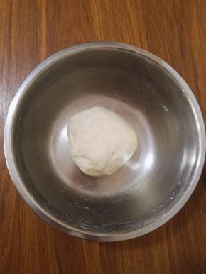 2、酵母粉与清水混合均匀，加入面粉中，揉成柔软的面团，用保鲜膜盖好饧发30分钟。