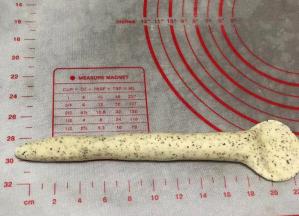 搓成22厘米长条，注意这时面团的粘合处整形时要放下边，不然烤的时候会开裂。一侧用擀面杖压平