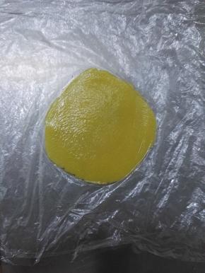 9、取出一个小面团，夹在保鲜膜的中间，用擀面杖擀成圆形。