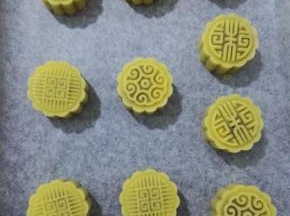 14、用月饼模具压出花形，烤箱预热上火190度，下火170度，预热完成，用喷壶在月饼上喷点水后放入烤箱，烤10分钟至月饼的表面微微上色。