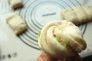 两手拽住两头，分别向相反方向扭，收口在下面捏紧，就成了一个花卷。