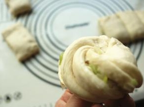 两手拽住两头，分别向相反方向扭，收口在下面捏紧，就成了一个花卷。