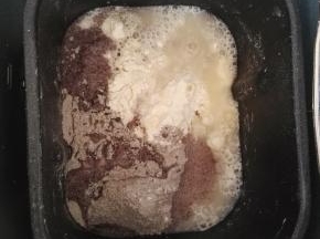 2、将面包粉、黑米面、白糖、鸡蛋、清水、耐高糖酵母倒入面包桶中，启动揉面程序。