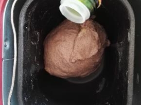 4、面团变得光滑，能拉出较粗糙的薄膜时，加入橄榄油，继续揉面程序。