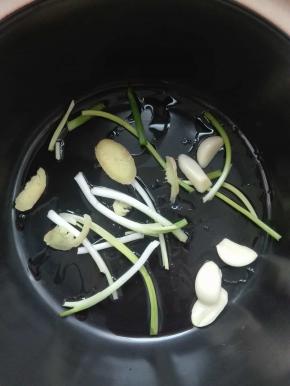 青棍买回来，在菜场里已经杀好。清洗干净。砂锅里抹一层油，放入葱段，姜片，蒜头。