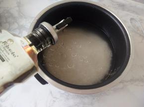 按比例加入水，我一般按经验用手试，手掌平放在米上，水没过手背即可。一般可按1：1或1：1.2来，这个请根据自已的喜好。我还喜欢在米中加入几滴食用油。