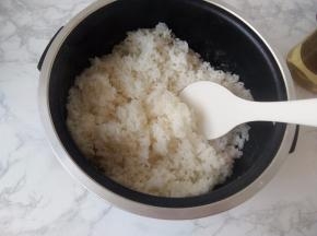 将在电饭煲中做好的米饭趁热划松散。