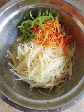 4、将土豆丝、青椒丝、胡萝卜丝放在盆中。