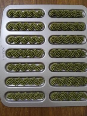 8、将面粉糊以S形挤在烤盘上，烤箱预热上火180度下火170度，预热完成将烤盘放入烤箱，烤制15分钟，饼干底部均匀上色，取出晾凉即可。