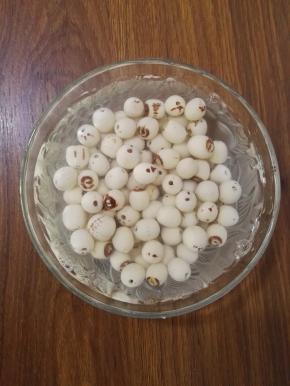 2、莲子清洗干净，浸泡于清水中，待莲子稍微软些时，用针将莲子内残余的莲子芯去除。