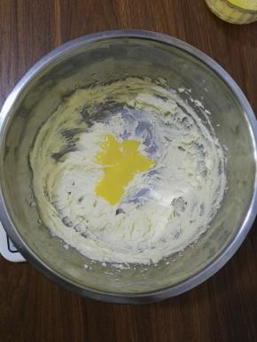 4、加入三分之一的蛋液，打至顺滑，让蛋液与黄油糊混合均匀，再将剩余的蛋液分两次加入黄油糊中，并与黄油混合均匀。