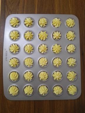 9、在模具上挤出大小均匀的花形，烤箱预热上火180度，下火160度，预热完成将模具放入烤箱，烤制12分钟，待饼干均匀上色后取出晾凉即可。