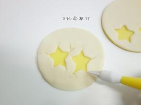 黄色薄片刷一点点糖水压上白色薄片粘合好，用工具压出鸡蛋裂缝