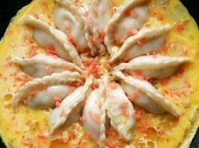 到水差不多烧干的时候，把鸡蛋搅成蛋液，围着饺子边缘倒进去，然后再撒上胡萝卜