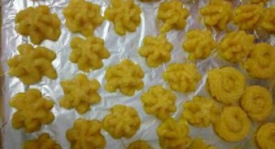 烤盘铺上油纸，用裱花袋面糊挤出花型