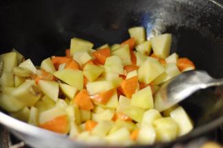 5、然后加入胡萝卜，继续炒至土豆变色