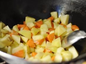 5、然后加入胡萝卜，继续炒至土豆变色