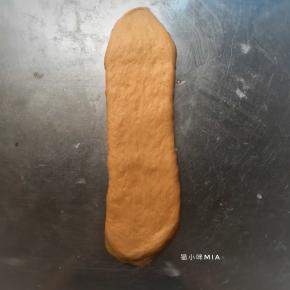 将二次松弛好的面团再擀开，从上往下卷起，放入吐司盒中