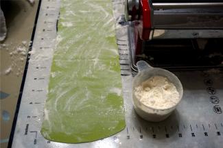 准备出面条时，先给面片的正反面撒上富强粉，目的是防止面条沾粘。