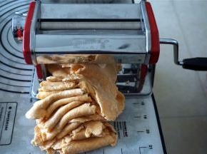 开始用最厚的7档压面，初次压面2次，将盆里的干粉里包到面块中，然后放入压面机压面，压两次后就没有干粉了。