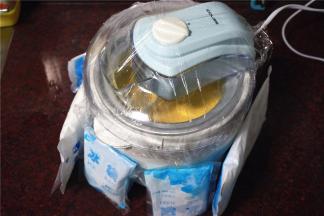 然后用保鲜膜封住雪糕机的料口，周围围上冰袋，营造冷冷的环境，大概搅拌20分钟。
