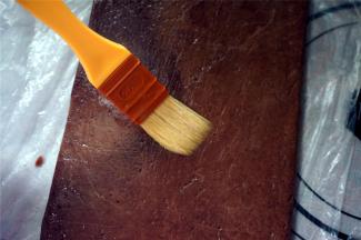 将冻硬了的面片取出，撕开保鲜袋，在其中一片面片上刷上一层全蛋液。