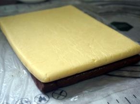 将另外一片面片放在刷了蛋液的面片上，稍微用手压紧一下，然后包上保鲜膜，重新放入冰箱冷冻1个小时。