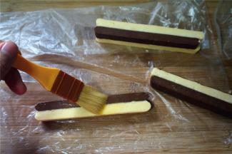 刷上一层蛋液后，两条双色条形叠放在一起，注意是不同的颜色叠放在一起，形成棋格花纹。