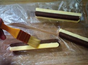 刷上一层蛋液后，两条双色条形叠放在一起，注意是不同的颜色叠放在一起，形成棋格花纹。