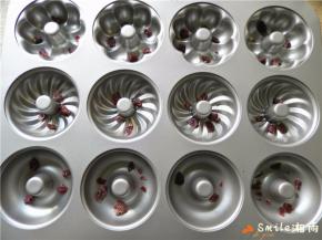 模具用毛刷蘸点玉米油刷模具，再分别撒入切碎的蔓越莓干。